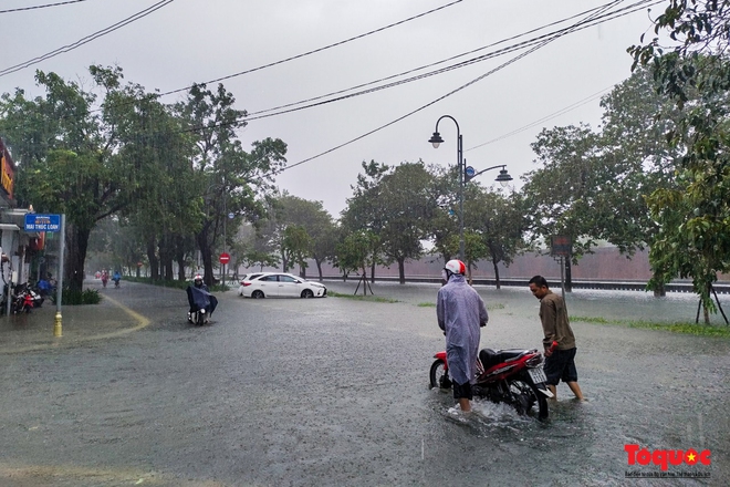 Khách Tây trải nghiệm đi thuyền giữa phố, người dân giăng lưới bắt cá bên Kinh thành Huế sau mưa - Ảnh 1.