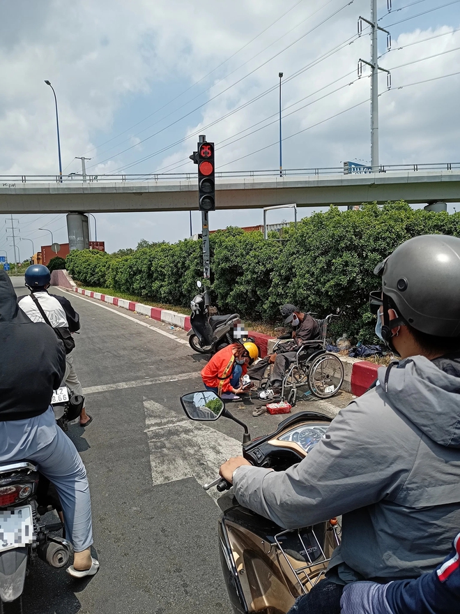 Xúc động hình ảnh người phụ nữ đi chân trần, thay đôi giày mới của mình cho chú bán hàng rong tàn tật bên đường - Ảnh 1.