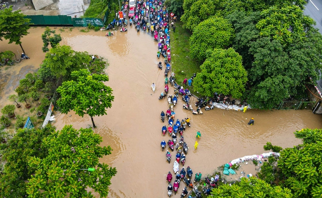 Ảnh: Đại lộ Thăng Long ngập sâu trong nước, hàng nghìn người dân vất vả dắt xe đi làm - Ảnh 3.