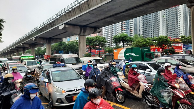 Đường phố Hà Nội ùn tắc nghiêm trọng trong ngày mưa lớn, người dân vất vả di chuyển đi học, đi làm - Ảnh 6.