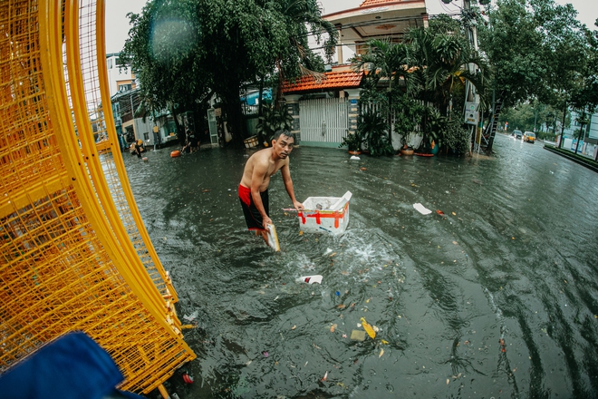 TP.HCM mưa trắng trời khiến nhiều tuyến phố ngập sâu: Người dân chật vật tát nước khỏi nhà, trẻ nhỏ thích thú nô đùa - Ảnh 8.