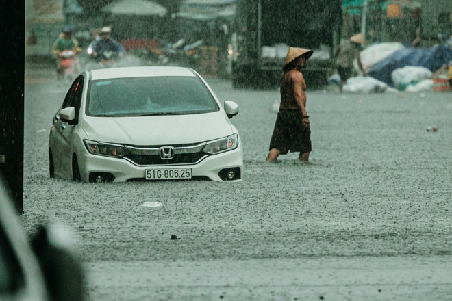 TP.HCM mưa trắng trời khiến nhiều tuyến phố ngập sâu: Người dân chật vật tát nước khỏi nhà, trẻ nhỏ thích thú nô đùa - Ảnh 3.