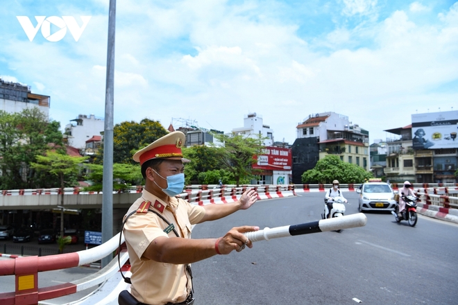 Cảnh sát giao thông Hà Nội đẫm mồ hôi làm nhiệm vụ giữa nắng đổ lửa - Ảnh 1.