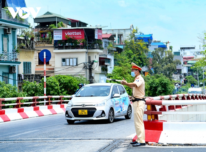 Cảnh sát giao thông Hà Nội đẫm mồ hôi làm nhiệm vụ giữa nắng đổ lửa - Ảnh 3.