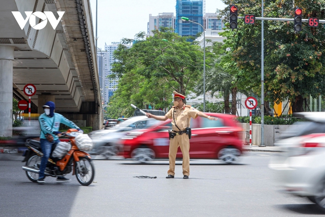 Cảnh sát giao thông Hà Nội đẫm mồ hôi làm nhiệm vụ giữa nắng đổ lửa - Ảnh 5.