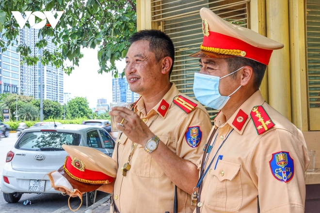 Cảnh sát giao thông Hà Nội đẫm mồ hôi làm nhiệm vụ giữa nắng đổ lửa - Ảnh 8.