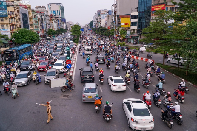 Lái xe máy vô tư đi ngược chiều trước mặt CSGT tại nút giao thông nóng Hà Nội - Ảnh 2.