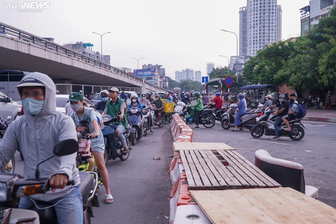 Lái xe máy vô tư đi ngược chiều trước mặt CSGT tại nút giao thông nóng Hà Nội - Ảnh 3.