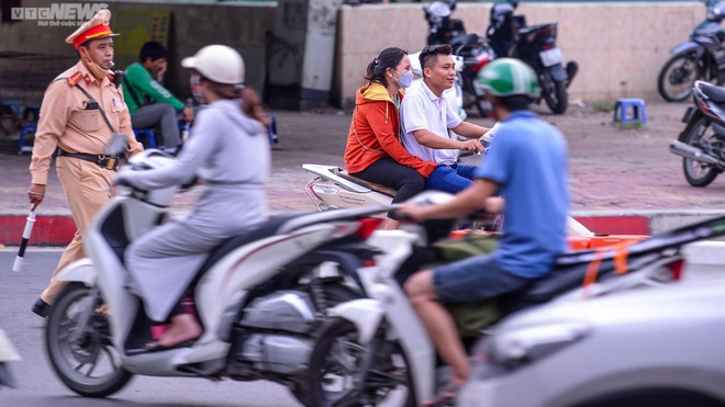 Lái xe máy vô tư đi ngược chiều trước mặt CSGT tại nút giao thông nóng Hà Nội - Ảnh 4.