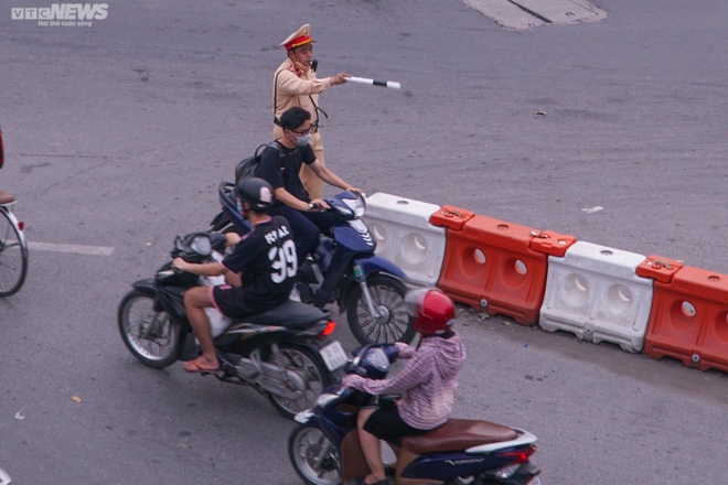Lái xe máy vô tư đi ngược chiều trước mặt CSGT tại nút giao thông nóng Hà Nội - Ảnh 5.