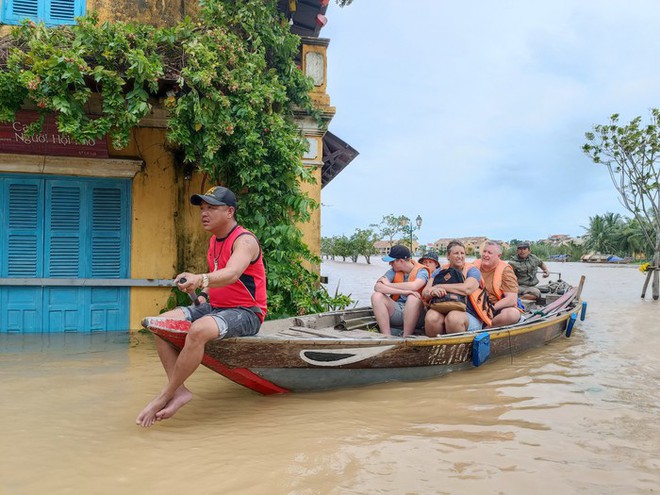 Du khách nước ngoài dọn rác sau bão ở Hội An - Ảnh 1.