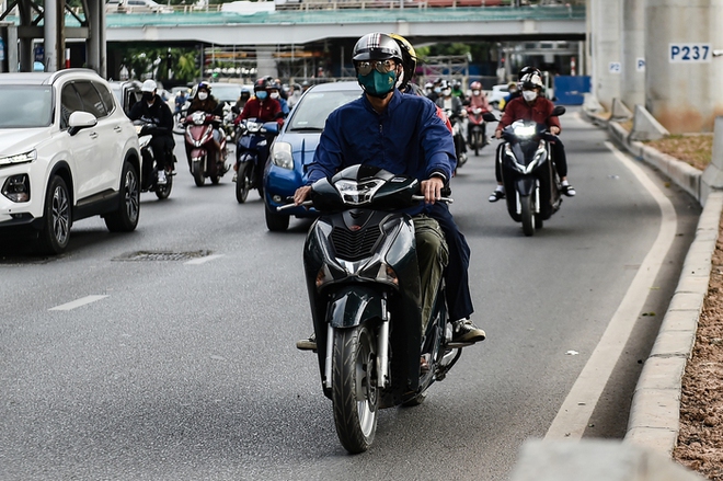 Không khí lạnh tràn về, người dân Hà Nội mặc áo ấm, che mặt kín mít khi ra đường - Ảnh 3.