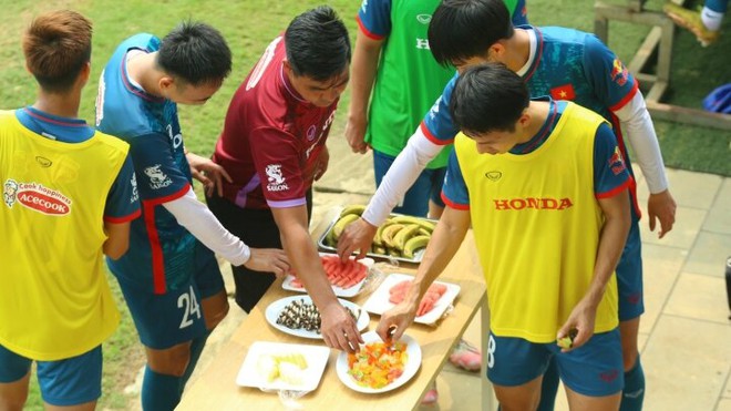 Khoa học tr&ecirc;n b&agrave;n ăn đầy b&aacute;nh kẹo, hoa quả ở s&acirc;n tập của U23 Việt Nam - Ảnh 1.
