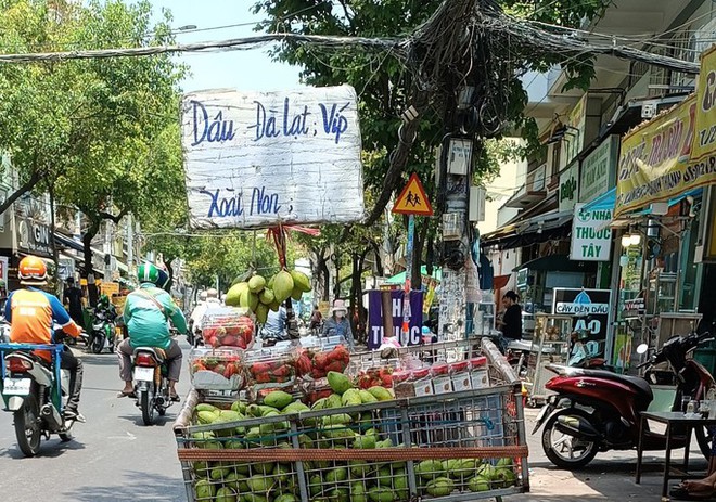 Bà nội trợ TP.HCM choáng ngợp với dâu tây gắn mác Đà Lạt, Sơn La tràn ngập đường phố - Ảnh 1.