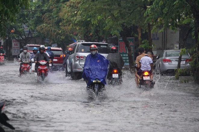 Mưa lớn sau chuỗi ng&agrave;y nắng n&oacute;ng, người d&acirc;n TP.HCM lại b&igrave; b&otilde;m lội nước v&igrave; đường ngập - Ảnh 3.
