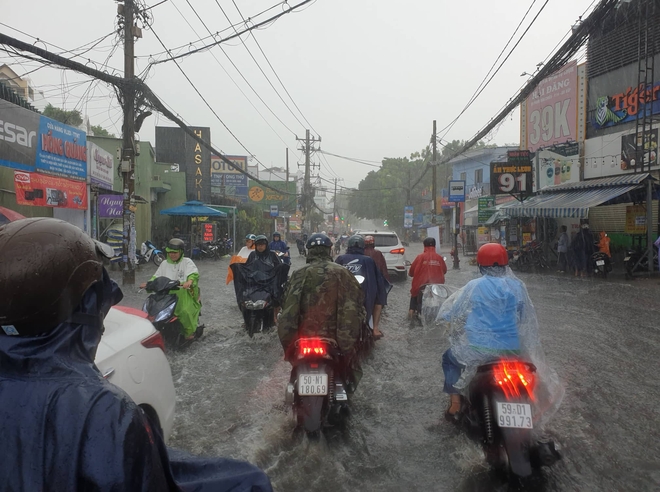 Mưa lớn sau chuỗi ngày nắng nóng, người dân TP.HCM lại bì bõm lội nước vì đường ngập - Ảnh 2.
