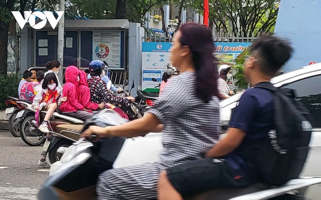 Nhiều phụ huynh H&agrave; Nội kh&ocirc;ng đội mũ bảo hiểm, lượn l&aacute;ch trong giờ tan tầm đi đ&oacute;n con - Ảnh 8.