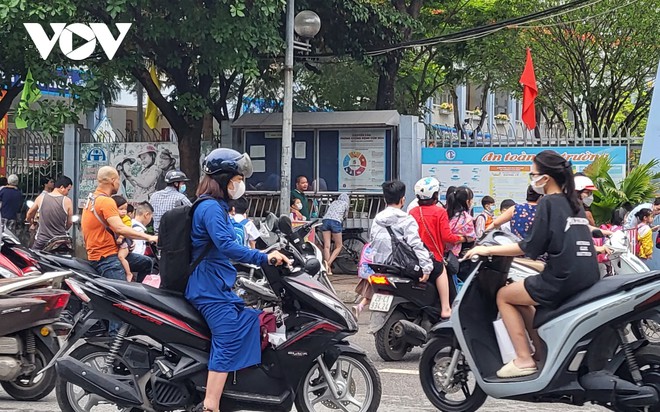 Nhiều phụ huynh H&agrave; Nội kh&ocirc;ng đội mũ bảo hiểm, lượn l&aacute;ch trong giờ tan tầm đi đ&oacute;n con - Ảnh 7.
