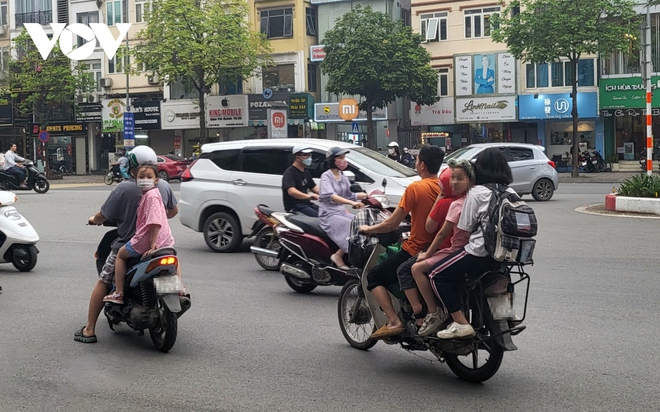 Nhiều phụ huynh H&agrave; Nội kh&ocirc;ng đội mũ bảo hiểm, lượn l&aacute;ch trong giờ tan tầm đi đ&oacute;n con - Ảnh 5.