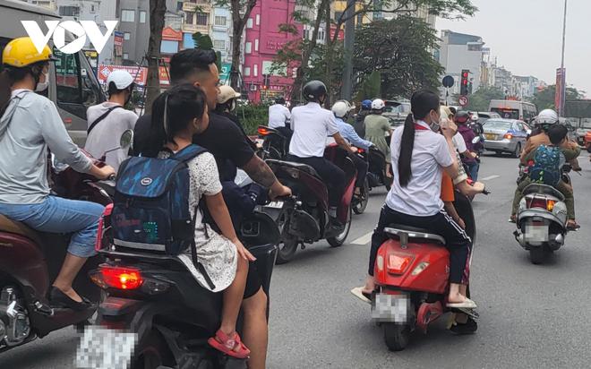 Nhiều phụ huynh H&agrave; Nội kh&ocirc;ng đội mũ bảo hiểm, lượn l&aacute;ch trong giờ tan tầm đi đ&oacute;n con - Ảnh 4.