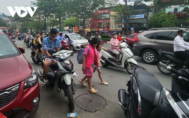 Nhiều phụ huynh H&agrave; Nội kh&ocirc;ng đội mũ bảo hiểm, lượn l&aacute;ch trong giờ tan tầm đi đ&oacute;n con - Ảnh 2.