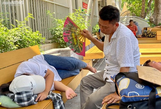 Người nhà bệnh nhân vật vã dưới nắng nóng hơn 50 độ C ở Hà Nội - Ảnh 7.