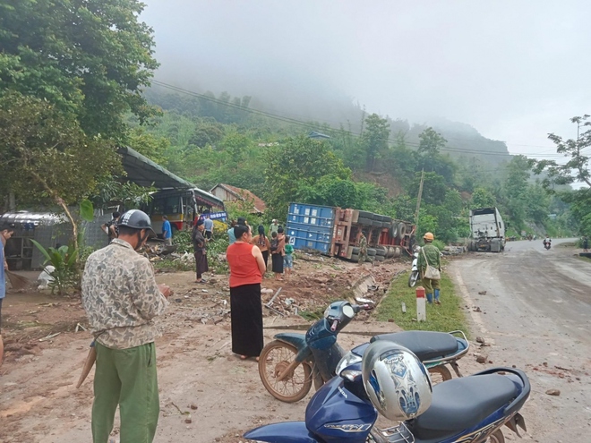 Mất lái khi đổ đèo, xe đầu kéo đâm vào xe bus đỗ trong sân nhà - Ảnh 1.