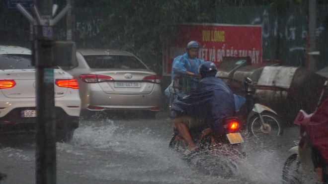Mưa lớn bất ngờ ở H&agrave; Nội khiến nhiều người trở tay kh&ocirc;ng kịp, xe cộ vật lộn trong nước - Ảnh 7.