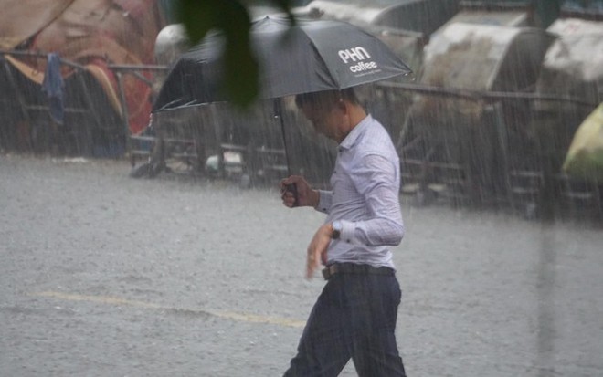 Mưa lớn bất ngờ ở H&agrave; Nội khiến nhiều người trở tay kh&ocirc;ng kịp, xe cộ vật lộn trong nước - Ảnh 4.