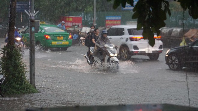 Mưa lớn bất ngờ ở H&agrave; Nội khiến nhiều người trở tay kh&ocirc;ng kịp, xe cộ vật lộn trong nước - Ảnh 2.