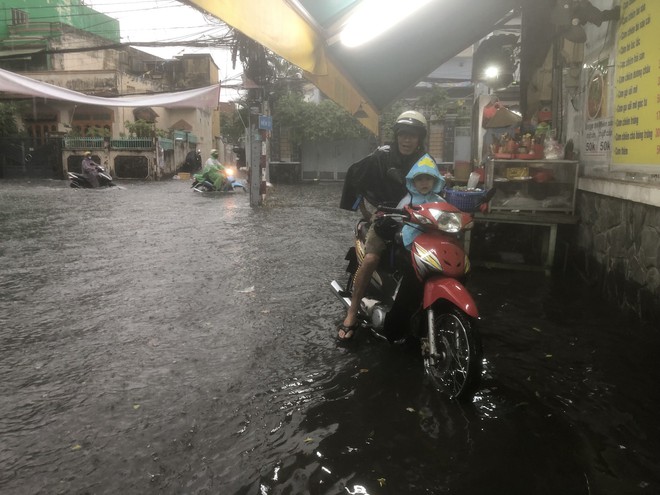 Nhiều tuyến đường TPHCM hóa sông sau mưa lớn, người dân vật vã chạy ngập - Ảnh 1.