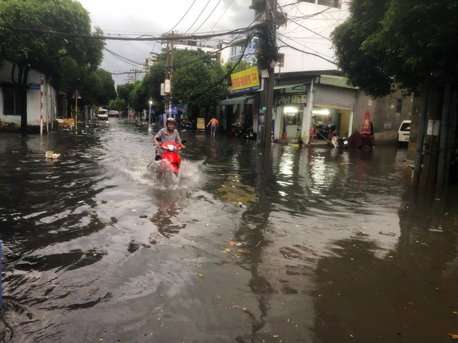 Nhiều tuyến đường TPHCM hóa sông sau mưa lớn, người dân vật vã chạy ngập - Ảnh 6.