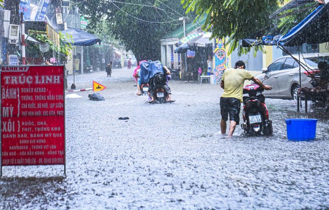 Đường phố Hà Nội biến thành “sông”, người dân bì bõm lội nước - Ảnh 9.