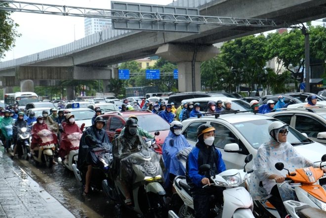 Giao thông nhiều nơi ở Hà Nội tê liệt trong trận mưa lớn: Từ sáng sớm đến trưa vẫn ùn tắc kéo dài - Ảnh 3.