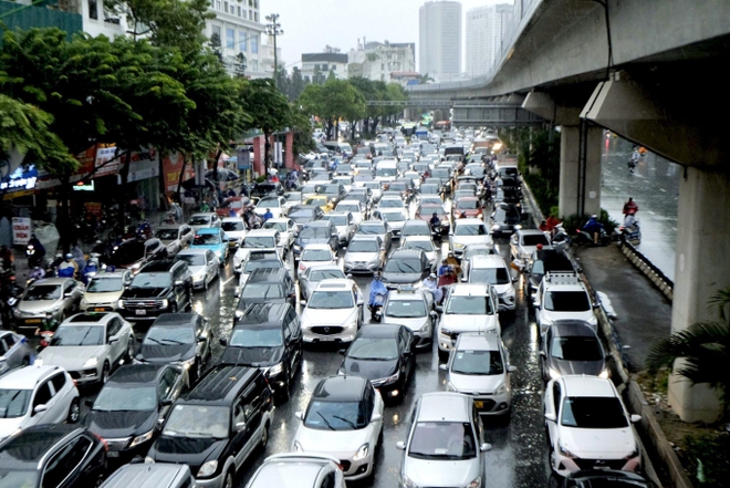 Giao thông nhiều nơi ở Hà Nội tê liệt trong trận mưa lớn: Từ sáng sớm đến trưa vẫn ùn tắc kéo dài - Ảnh 1.