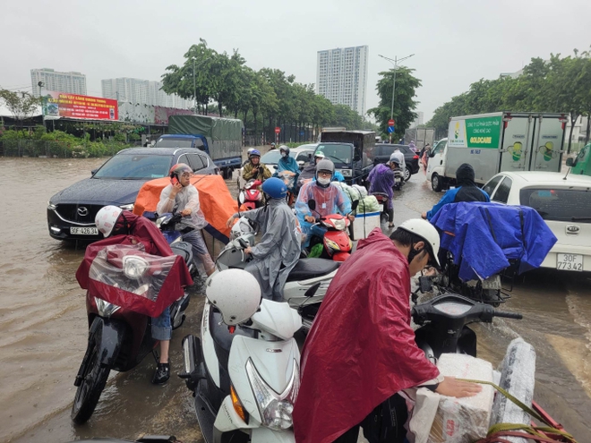 Giao thông nhiều nơi ở Hà Nội tê liệt trong trận mưa lớn: Từ sáng sớm đến trưa vẫn ùn tắc kéo dài - Ảnh 11.