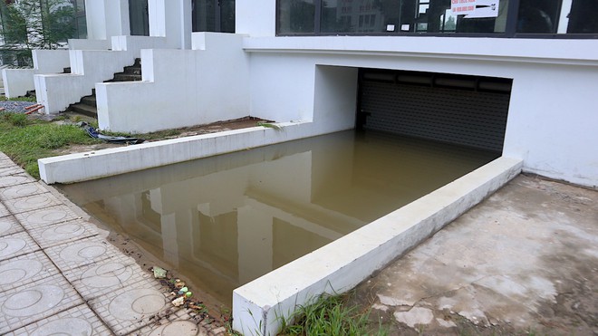 Sau mưa lớn, người d&acirc;n ở khu biệt thự triệu đ&ocirc; vẫn phải lội nước vớt đồ - Ảnh 1.