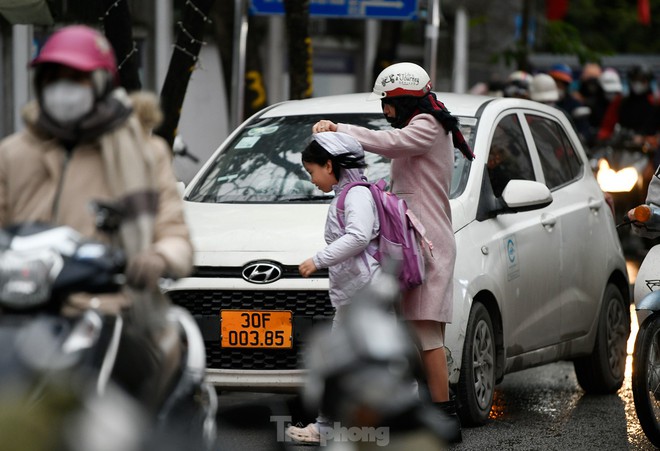 Hà Nội 12 độ C, người dân chật vật đi làm trong mưa lạnh - Ảnh 2.