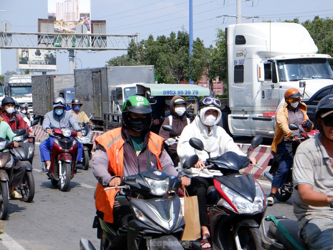 TPHCM nắng rát mặt từ nay đến Tết, người dân trùm kín mít khi ra đường - Ảnh 4.