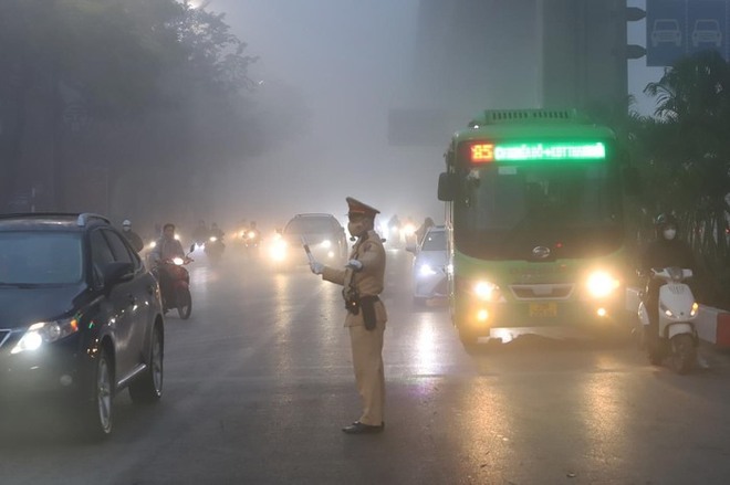 Cảnh sát giao thông Hà Nội bám đường, phân luồng người dân di chuyển trong thời tiết sương mù - Ảnh 1.