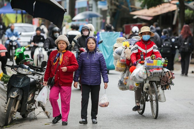 Trái ngược với cái nóng rát mặt ở TPHCM, người dân Hà Nội co ro, chống chọi với mưa rét 13 độ C - Ảnh 2.