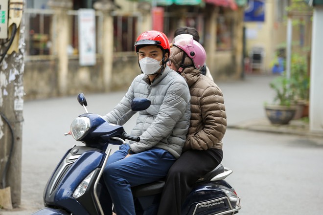 Trái ngược với cái nóng rát mặt ở TPHCM, người dân Hà Nội co ro, chống chọi với mưa rét 13 độ C - Ảnh 1.