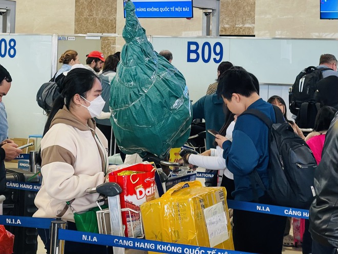 Sân bay Nội Bài đông nghẹt ngày 28 Tết, hành khách vạ vật, nằm ngồi la liệt - Ảnh 6.