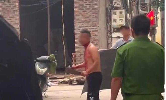 Thanh ni&ecirc;n ng&aacute;o đ&aacute; chạy tr&ecirc;n đường phố H&agrave; Nội, cầm dao tự cắt cổ - Ảnh 1.