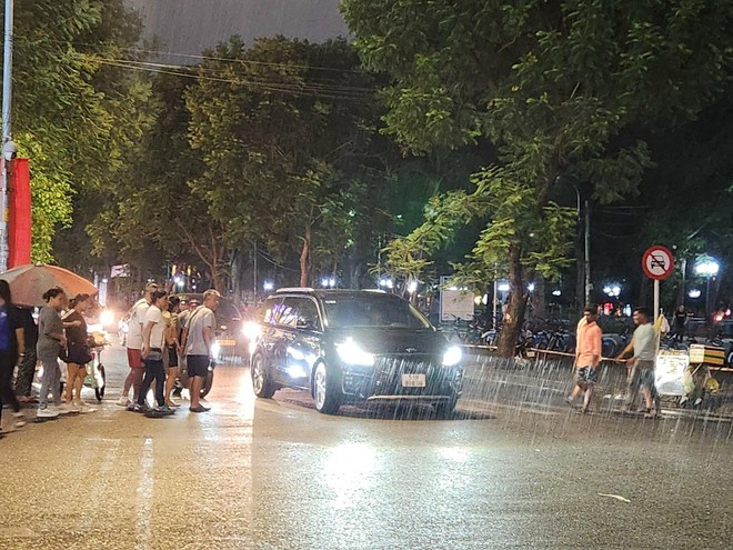 Trung tâm TP.HCM đón cơn mưa xối xả, người dân không kịp trở tay nhưng vẫn vui sướng sau bao ngày nắng nóng - Ảnh 3.