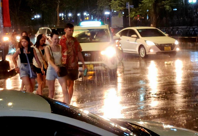 Trung tâm TP.HCM đón cơn mưa xối xả, người dân không kịp trở tay nhưng vẫn vui sướng sau bao ngày nắng nóng - Ảnh 6.