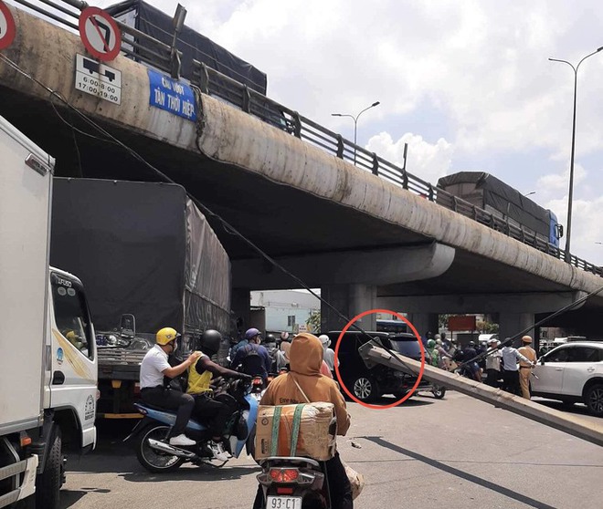 TPHCM: Trụ đèn khủng trên cầu đổ xuống đường, đè trúng một phụ nữ đi xe máy - Ảnh 2.