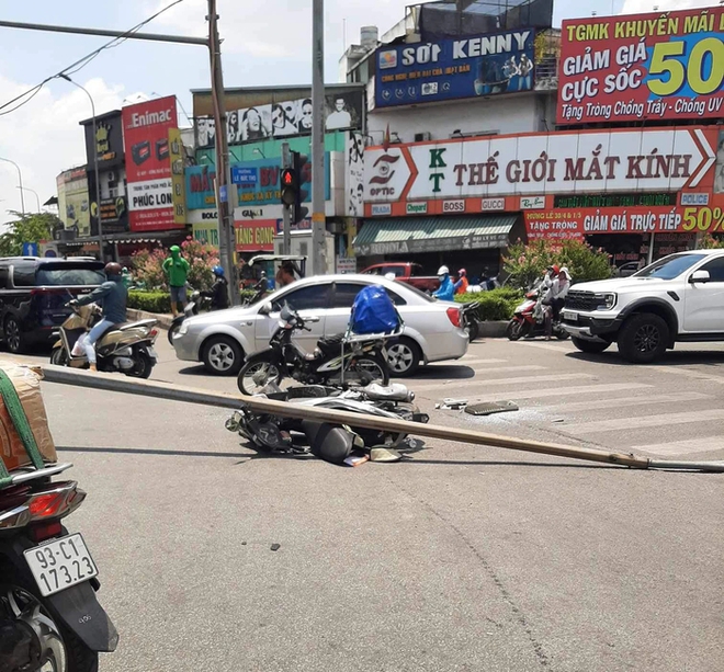 TPHCM: Trụ đèn khủng trên cầu đổ xuống đường, đè trúng một phụ nữ đi xe máy - Ảnh 1.