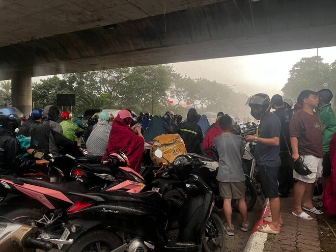 Mây đen ùn ùn kéo đến giăng kín trời Hà Nội, mưa như trút nước khiến nhiều người dân không kịp trở tay - Ảnh 7.