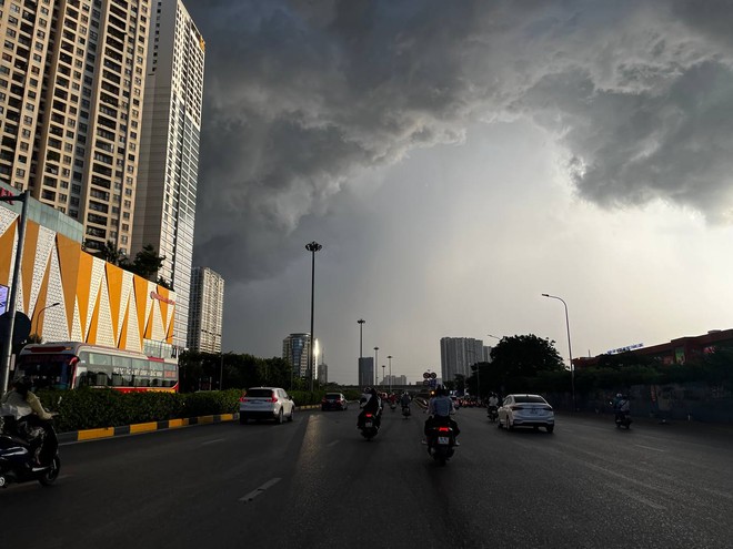 Mây đen ùn ùn kéo đến giăng kín trời Hà Nội, mưa như trút nước khiến nhiều người dân không kịp trở tay - Ảnh 4.